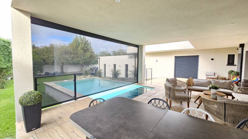 Fermeture d'une terrasse avec store sur mesure gris dans la Loire